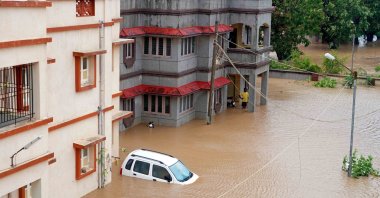 Residents watch as a car is left submerged by tidal water brought by Cyclone Biparjoy, Mandavi, India, June 16, 2023. (AFP Photo)