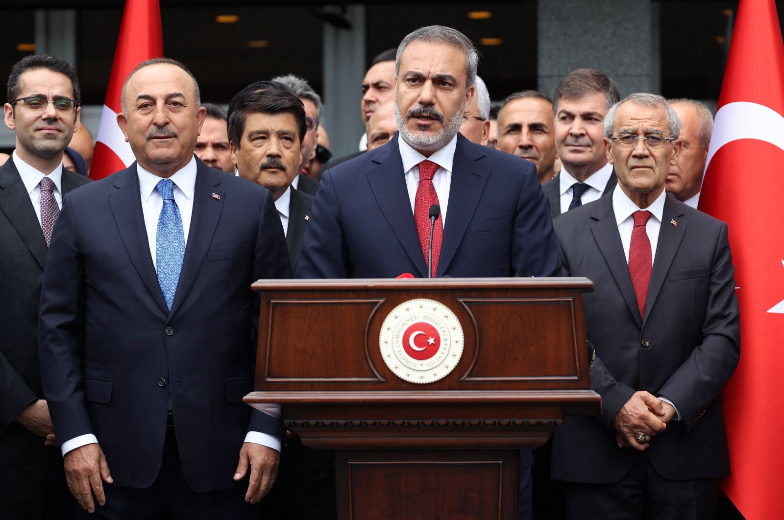 Newly appointed Foreign Minister Hakan Fidan (C) delivers a speech, flanked by his predecessor Mevlüt Çavuşoğlu (L), during a handover ceremony in Ankara, Türkiye, June 5, 2023. (AFP Photo)