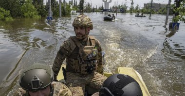 Ukrainian servicemen ride on a speedboat in a flooded neighborhood, in Kherson, Ukraine, June 8, 2023. (AP Photo)