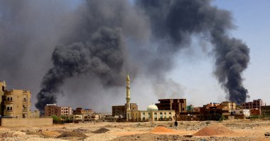 A man walks while smoke rises above buildings after aerial bombardments during clashes between the paramilitary Rapid Support Forces and the army in Khartoum North, Sudan, May 1, 2023. (Reuters File Photo)