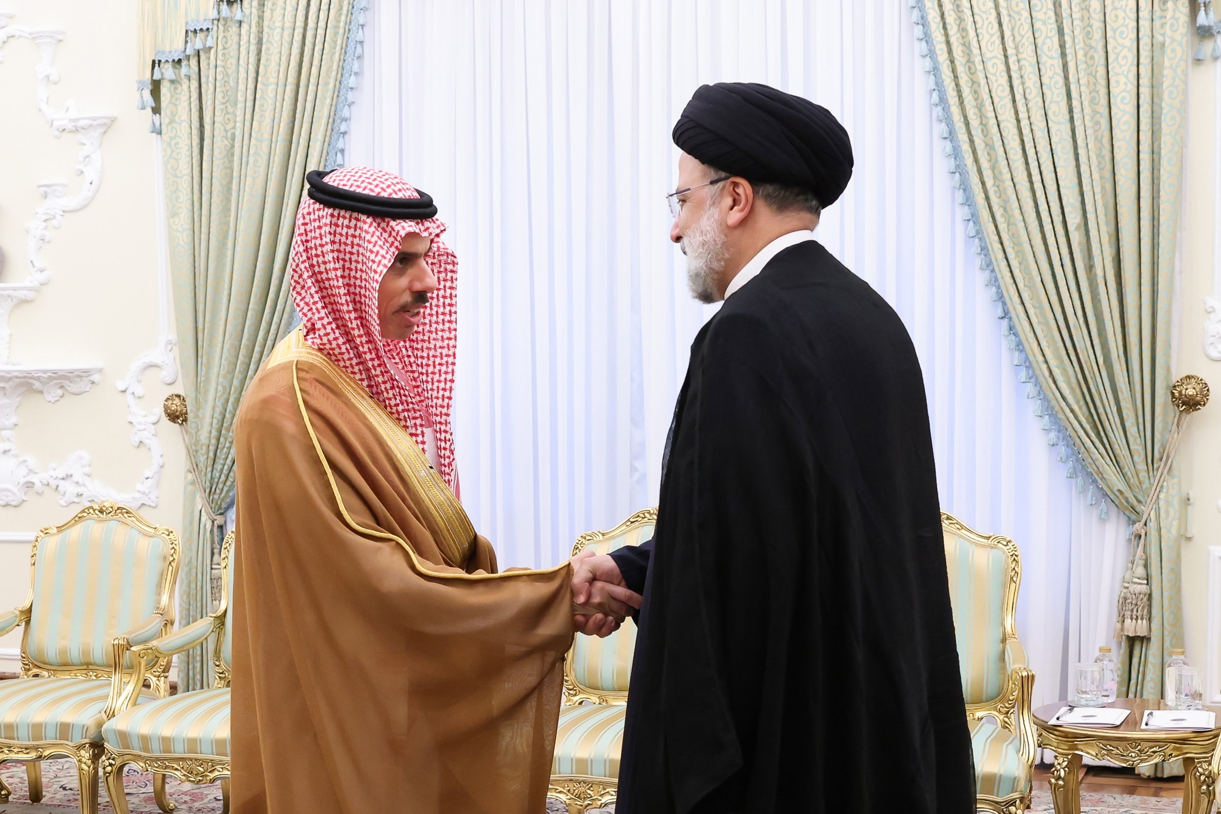 Presiden Iran Ebrahim Raisi (kanan) menyapa Menteri Luar Negeri Saudi Feisal bin Farhan selama pertemuan di Teheran, Iran, 17 Juni 2023. (Foto EPA)