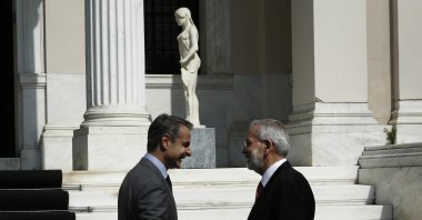 Greek Former Prime Minister Kyriakos Mitsotakis (L) shakes hands with new caretaker Prime Minister Ioannis Sarmas (R) during the handover ceremony at Maximos Mansion in Athens, Greece, 25 May 2023. (EPA Photo)