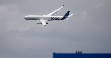 An Airbus A350-1000 performs its flying display next to a board reading "Boeing" during the International Paris Air Show, at Le Bourget Airport, near Paris, France, June 20, 2019. (AFP Photo)