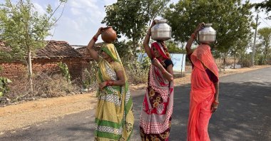 Women walk as they carry pitchers filled with drinking water on a hot summer afternoon in Lalitpur, Uttar Pradesh state, India, Saturday, June 17, 2023. (AP Photo)
