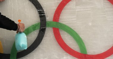 An ice maker sprays water over a cutout of the Olympic rings at a Beijing 2022 Winter Games venue, Beijing, China, Jan. 28, 2022. (AP Photo)