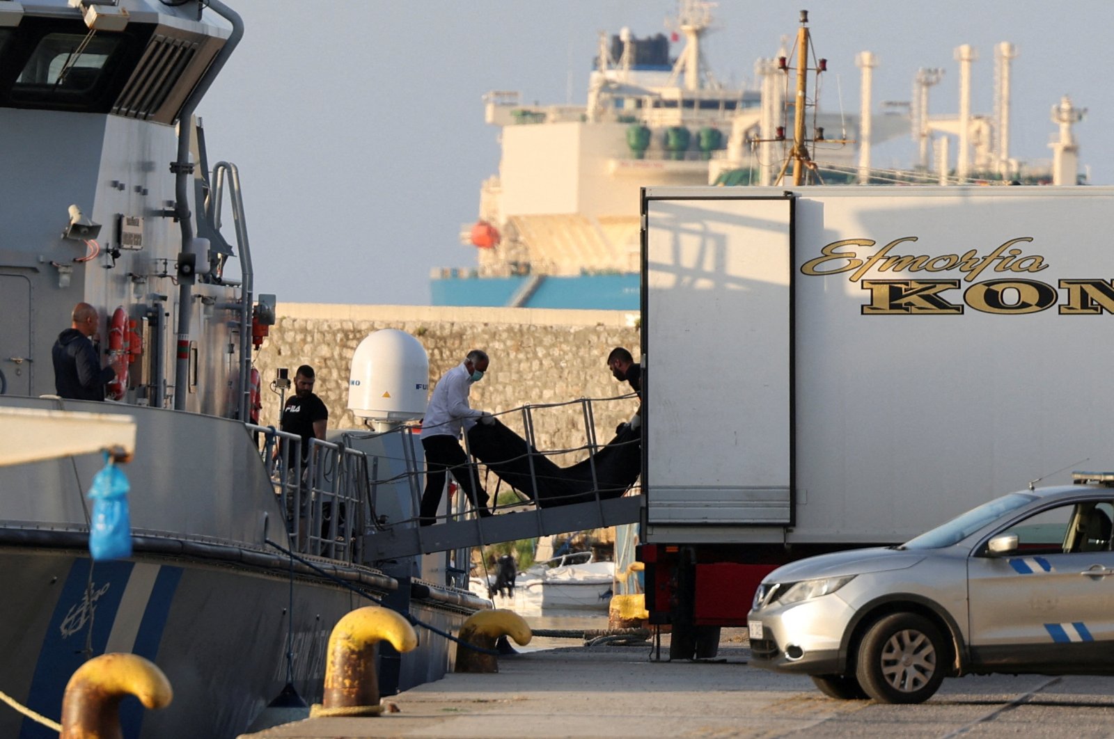 Men transfer body bags carrying migrants who died after their boat capsized in the open sea off Greece, onboard a Greek coast guard vessel at the port of Kalamata, Greece, June 15, 2023. (Reuters Photo)