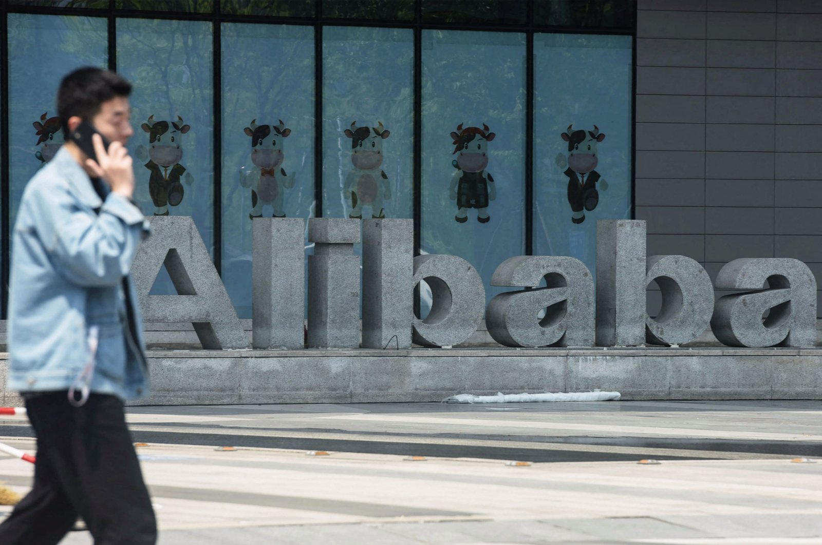 A man walks past Chinese e-commerce giant Alibaba&#039;s headquarters in Hangzhou, in China&#039;s eastern Zhejiang province, May 26, 2022. (AFP Photo)