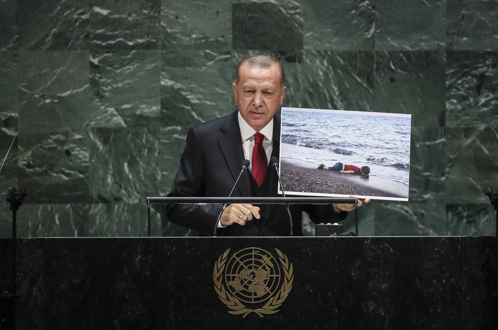 President Recep Tayyip Erdoğan holds a photo of Alan Kurdi, a young Syrian refugee who drowned in the Mediterranean Sea, while speaking at the U.N. General Assembly, in New York, U.S., Sept. 24, 2019. (AFP Photo)