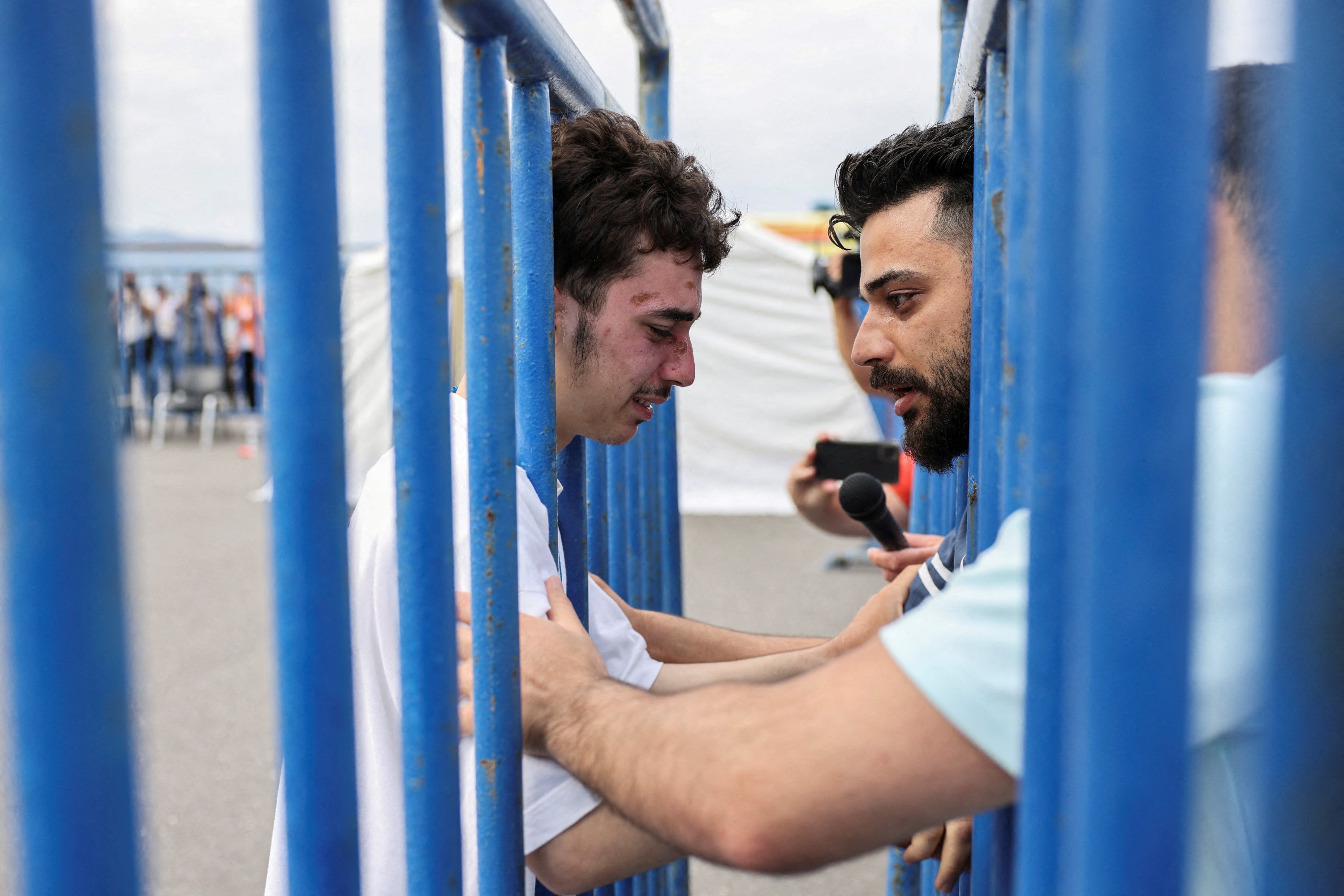 Mohammad, 18, penyintas Suriah, yang diselamatkan bersama pengungsi dan migran lain di laut lepas lepas pantai Yunani setelah kapal mereka terbalik, menangis saat bertemu kembali dengan saudaranya Fadi, yang datang menemuinya dari Belanda, di pelabuhan Kalamata, Yunani, Juni 16, 2023. (Foto Reuters)
