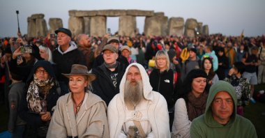 Revelers stand by the stones as they watch the sunrise at Stonehenge, near Amesbury, in Wiltshire, southern U.K., June 21, 2023. (AFP Photo)