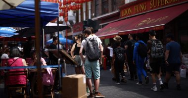 Members of the public read the menu outside a restaurant in the Chinatown area of Soho in London, Britain, June 18, 2023. (AFP Photo)