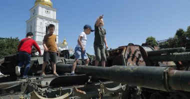 Children play on the damaged Russian military machinery displayed during an event to support children amid the Russian invasion, near St. Mykhailivsky Cathedral in Kyiv, Ukraine, June 4, 2023. (EPA Photo)