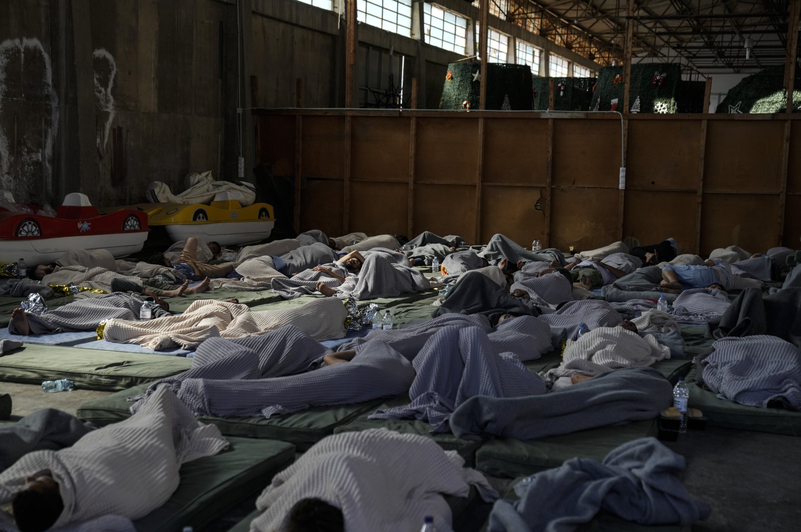 Survivors of a shipwreck sleep at a warehouse at the port in Kalamata town, about 240 kilometers southwest of Athens, Greece, June 14, 2023. (AP Photo)