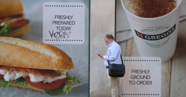 A man checks his phone outside a Greggs coffee shop in Manchester, Britain, June 22, 2023. (Reuters Photo)