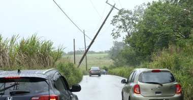 Cars pass a leaning power pole after Tropical Storm Bret passed north of the island, in St. Thomas, Barbados June 22, 2023. (Reuters Photo)