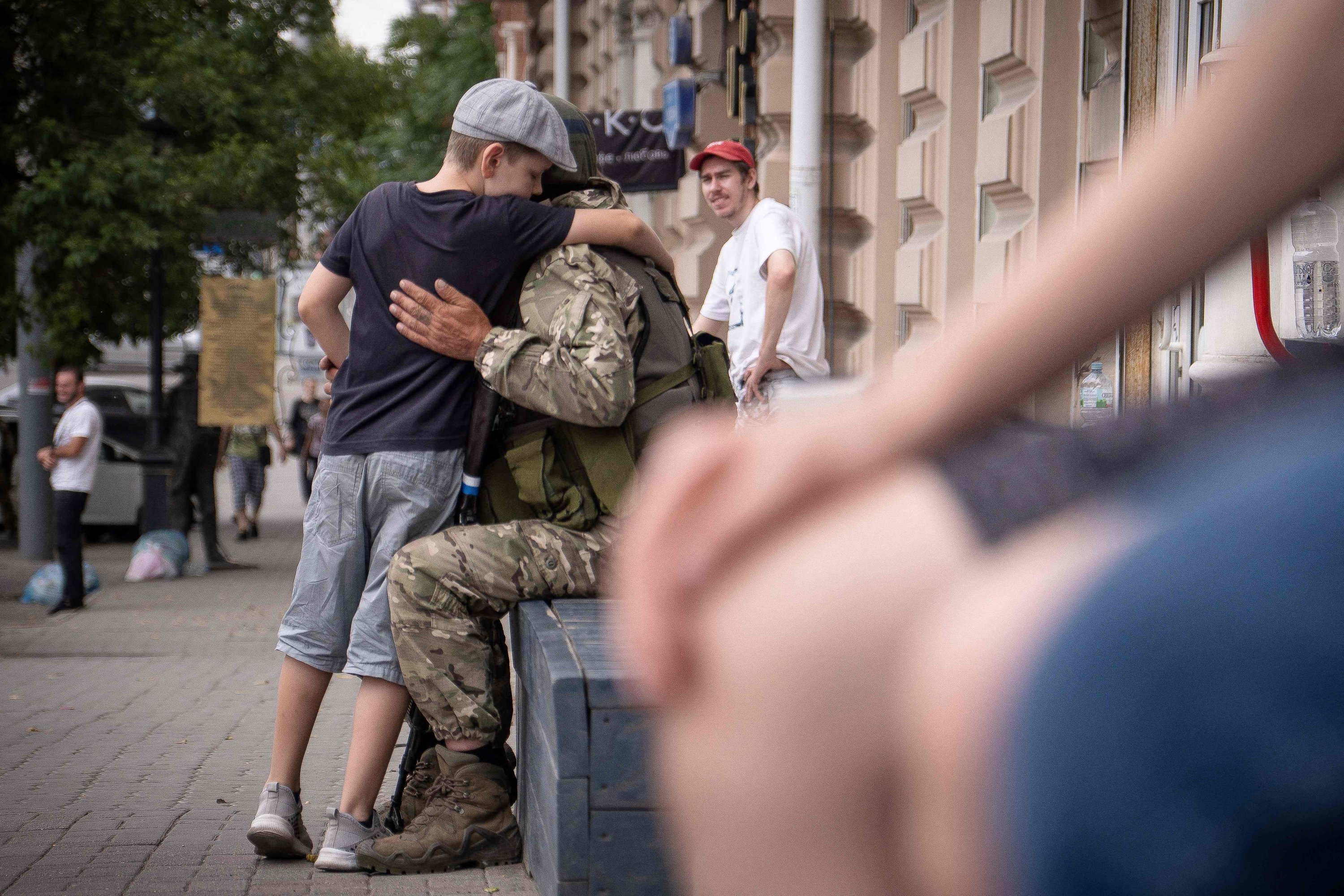 Seorang anak laki-laki memeluk anggota kelompok Wagner, Rostov-on-Don, Rusia, 24 Juni 2023. (Foto AFP)