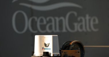The piece of equipment that reads "Titan" is pictured near a trailer with the OceanGate logo, Everett, Washington, June 22, 2023.  (AFP Photo)