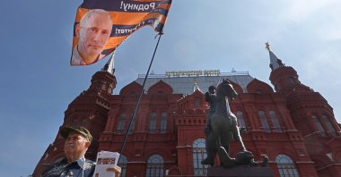 A member of the National Liberation Movement (NLM) holds a flag with a portrait of Russian President Putin in Moscow, Russia, June 25, 2023. (EPA Photo)