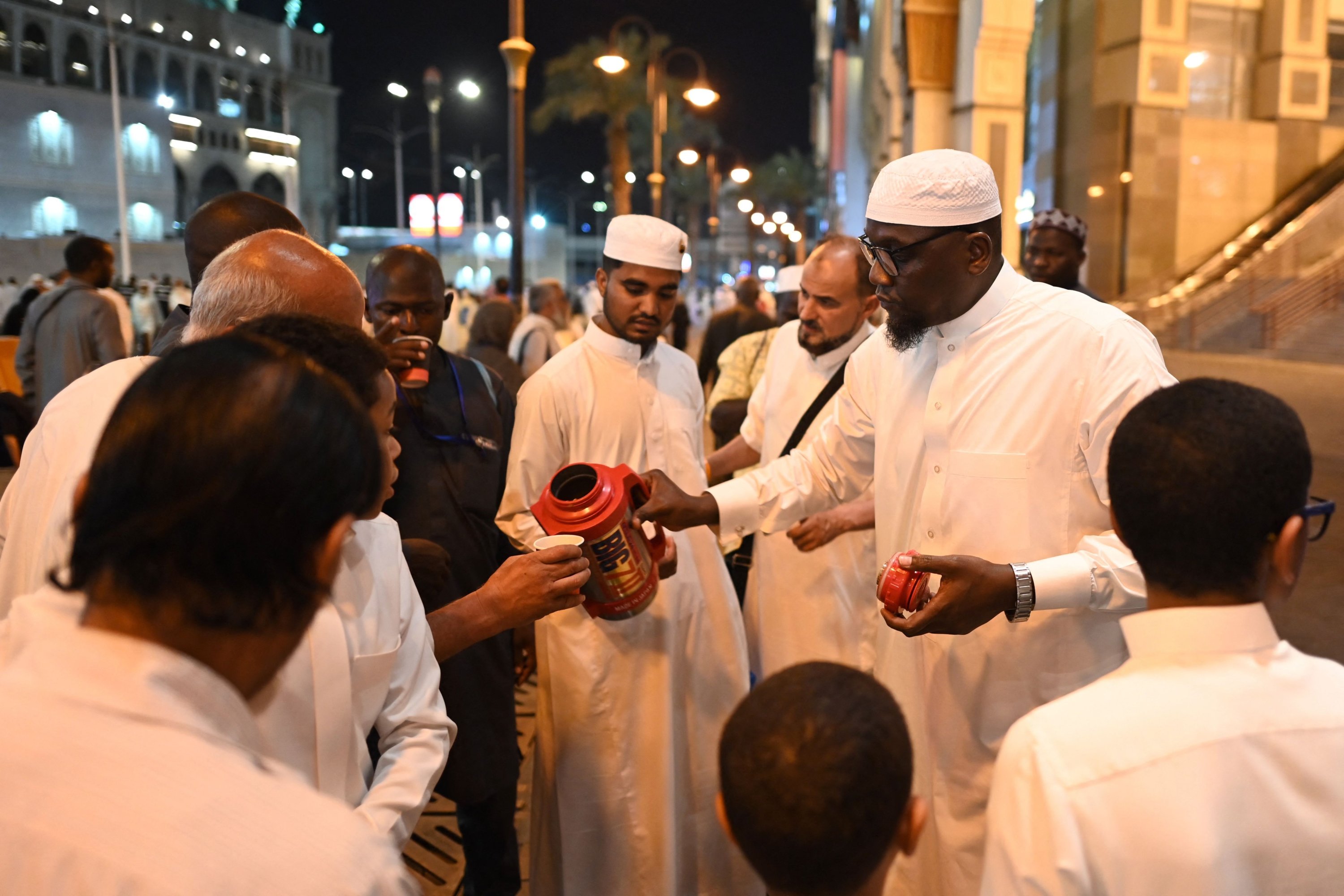 Sebuah keluarga Saudi membagikan teh gratis kepada jemaah haji di Mekkah, Arab Saudi, 23 Juni 2023. (AFP Photo)