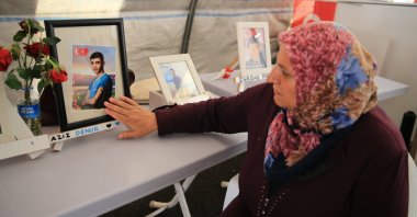 A mother caresses the picture of her son kidnapped by the PKK terror group as she waits for his return as part of the ongoing protest in front of the PKK-linked Peoples' Democratic Party (HDP) headquarters in southeastern Diyarbakır province, Türkiye, June 27, 2023. (AA Photo)