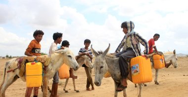 Yemeni children ride donkeys transporting water containers at a camp for displaced people in the Abs district of the country&#039;s northwestern Hajjah province, on May 30, 2023. (AFP File Photo)