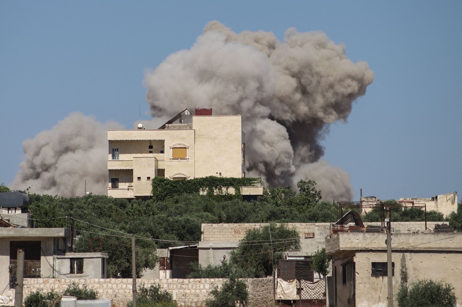A plume of smoke rises from a building following a reported Russian airstrike that killed at least 13 people including civilians and children in Syria&#039;s northwestern rebel-held Idlib province, on June 25, 2023. (AFP Photo)