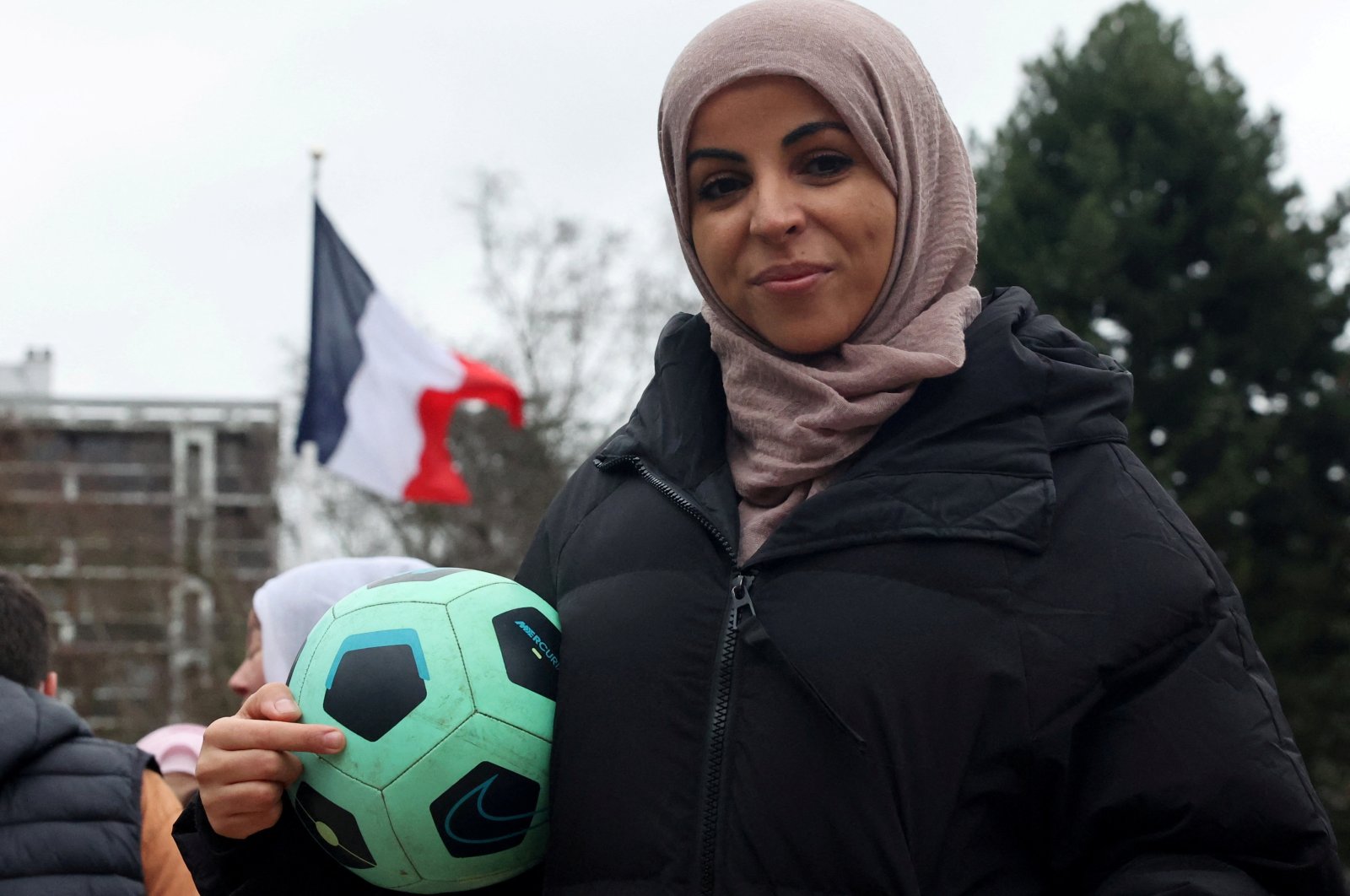 Writer Majid Siham poses with a football during a gathering to support the women&#039;s team &quot;Les Hijabeuses&quot; in front of the city hall in Lille as part of a protest as the French Senate examines a bill featuring a controversial hijab ban in competitive sports, Paris, France, Feb. 16, 2022. (Reuters Photo)