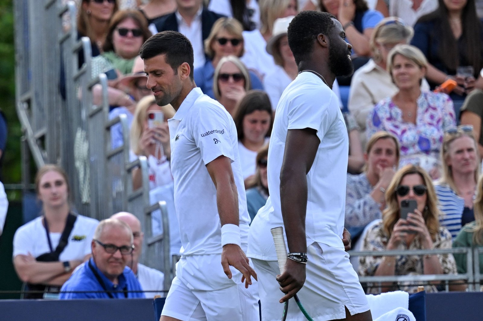 US player Frances Tiafoe (R) and Serbia&#039;s Novak Djokovic share a joke as they pass during their men&#039;s singles exhibition match at The Giorgio Armani Tennis Classic tournament at the Hurlingham Club, London, UK., June 29, 2023. (AFP Photo)