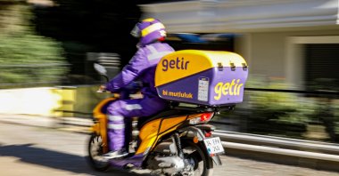 An employee of the Turkish fast grocery-delivery company Getir rides to deliver an online delivery in Istanbul, Türkiye, Nov. 12, 2021. (Reuters Photo)