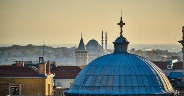 The Hagia Triada Greek Orthodox Church with the Galata Tower and Süleymaniye Mosque in the background, Istanbul, Türkiye. (Shutterstock Photo)