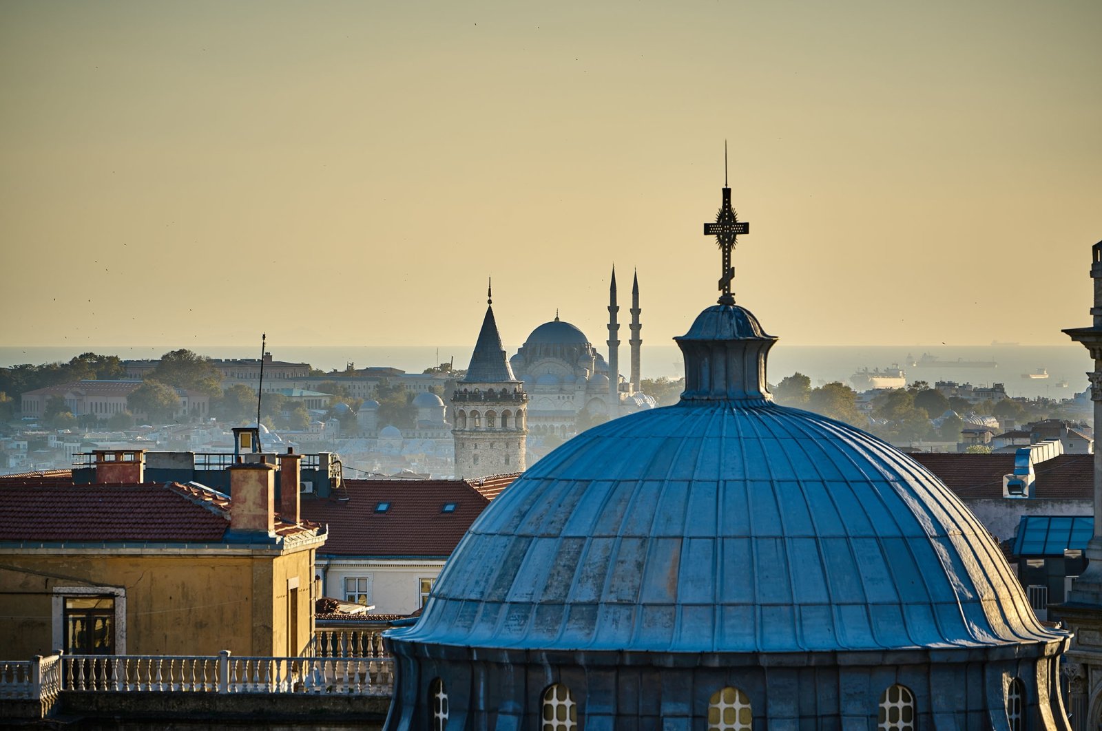 The Hagia Triada Greek Orthodox Church with the Galata Tower and Süleymaniye Mosque in the background, Istanbul, Türkiye. (Shutterstock Photo)