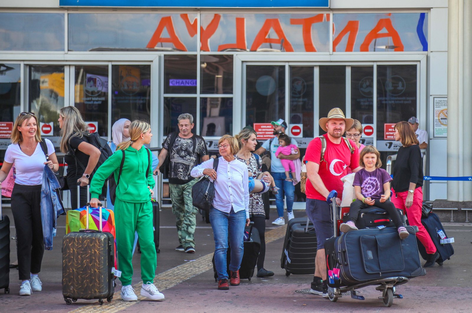 Tourists exit the airport as they arrive in the Mediterranean tourism hot spot Antalya, southern Türkiye, Sept. 22, 2022. (DHA Photo)