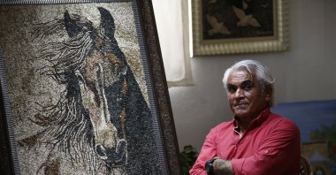 Artist Süleyman Sarı poses next to his work, in Antalya, Türkiye, July 2, 2023. (AA Photo)