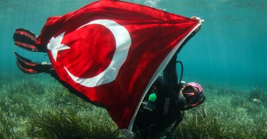 A group of diving instructors in Karaburun district unfurl the Turkish flag in the sea, Izmir, Türkiye, July 1, 2020. (AA Photo)