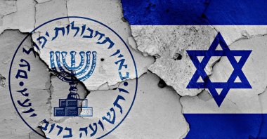 Logo of the Israeli intelligence agency Mossad and the Israeli flag painted on a cracked wall. (Shutterstock Photo)