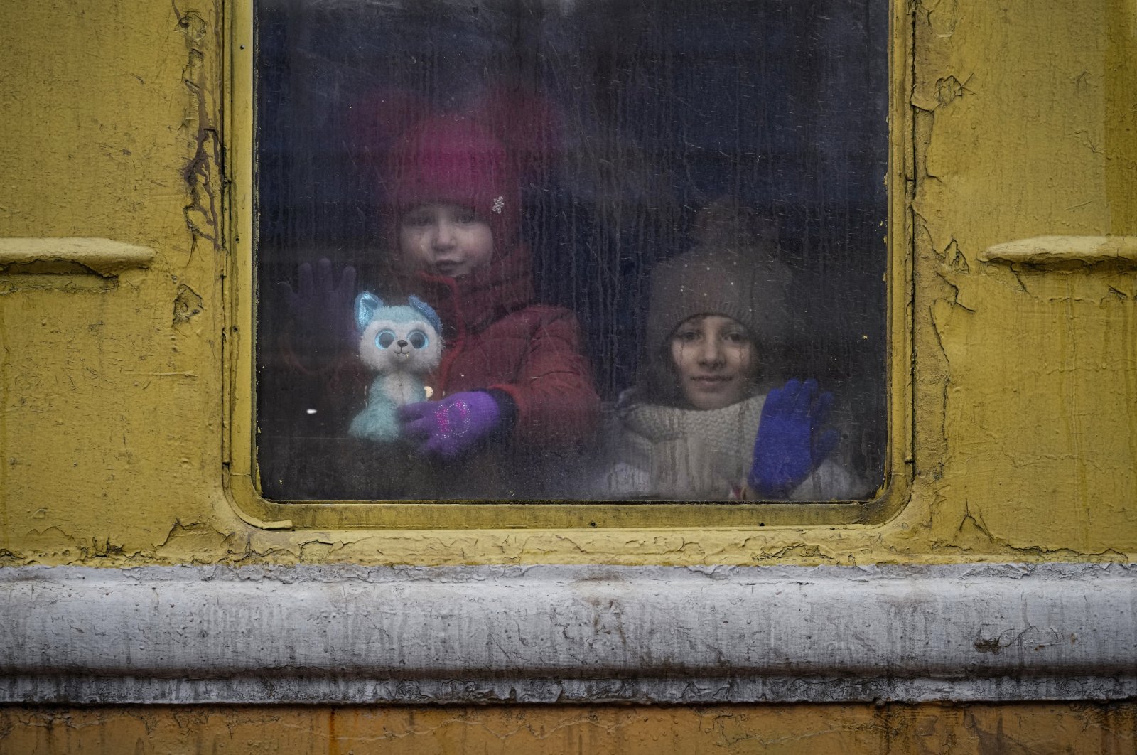 Children look out of the window of an unheated Lviv-bound train, in Kyiv, Ukraine, March 3, 2022. (AP Photo)
