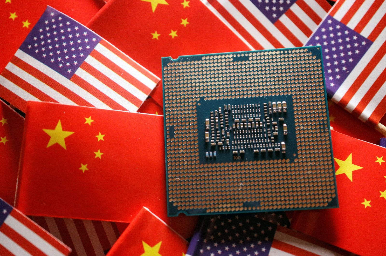 A central processing unit (CPU) semiconductor chip is displayed among flags of China and the U.S. in this illustration picture taken Feb. 17, 2023. (Reuters Photo)