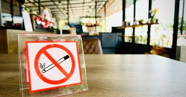 A no smoking sign on a wooden table of a coffee shop in a hotel, July 2, 2023. (Shutterstock Photo)