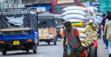 A labourer pulls a loaded handcart along a street at a wholesale market in Colombo, Sri Lanka, July 4, 2023. (AFP Photo)
