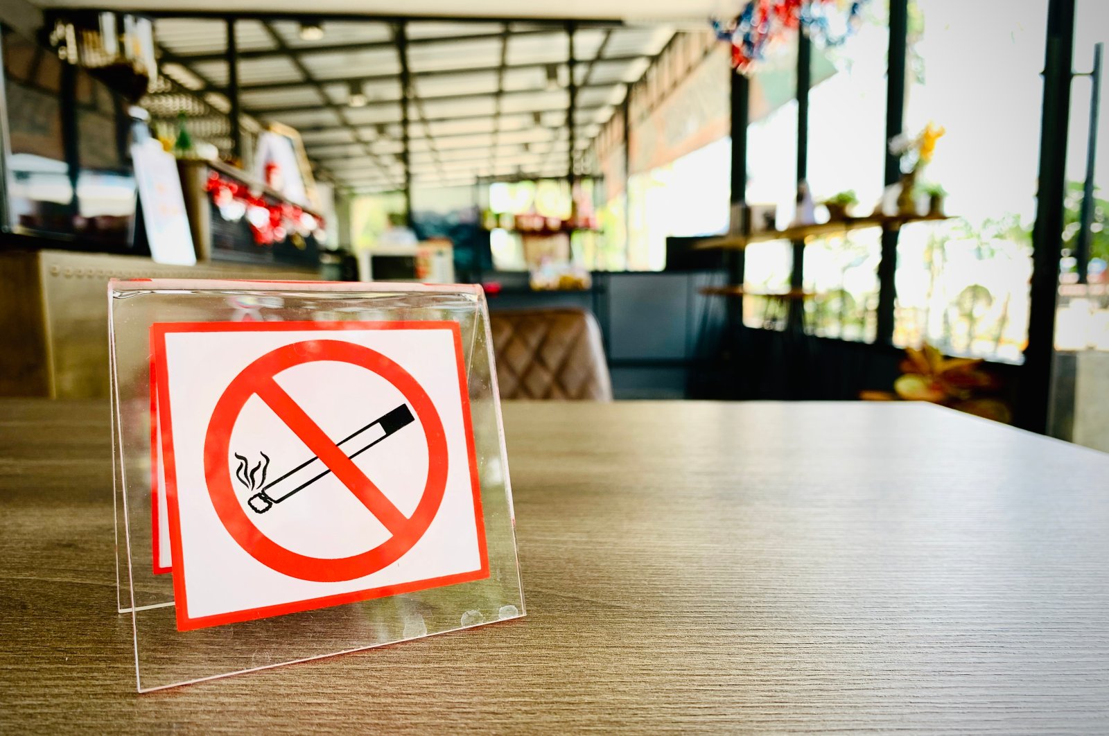 A no smoking sign on a wooden table of a coffee shop in a hotel, July 2, 2023. (Shutterstock Photo)