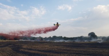 Fire at an area close to forest cover was brought under control by air and land intervention in the Kula district of Manisa, Türkiye, July 6, 2023. (IHA Photo)