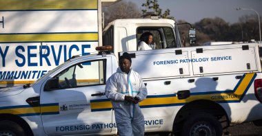 An investigator walks in front of a truck carrying bodies of gas leak victims, Boksburg, Johannesburg, South Africa, July 6, 2023. (EPA Photo)