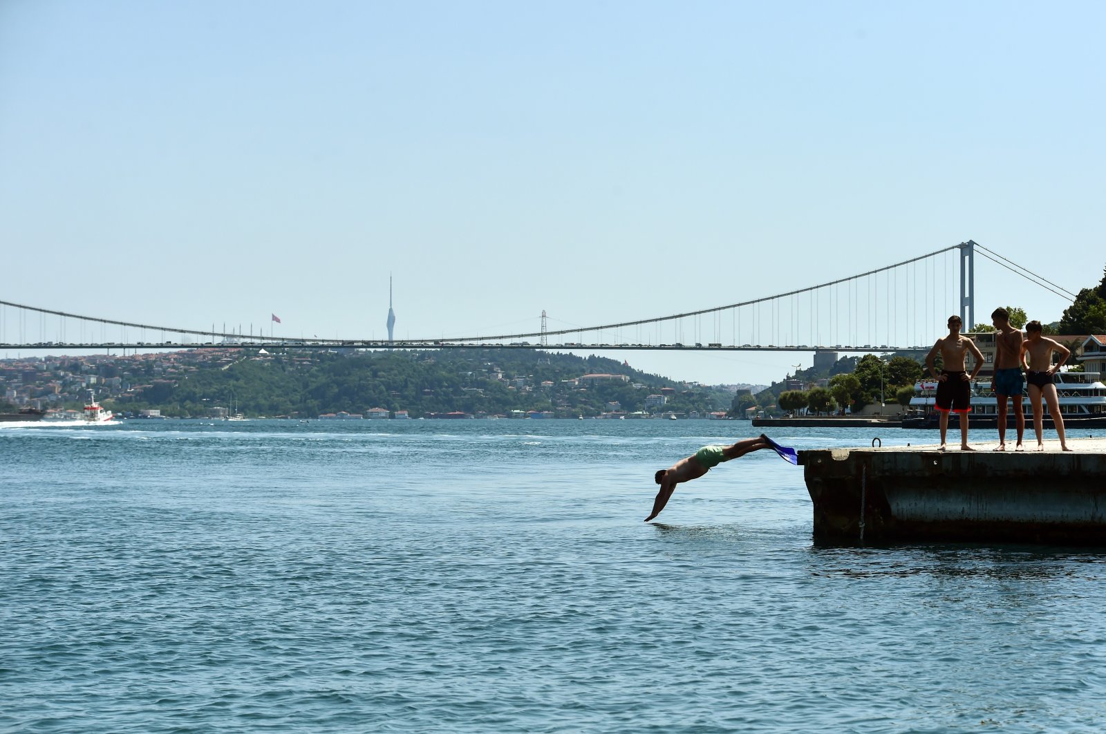 A swimmer dives into the Bosporus on a scorching summer day, Istanbul, Türkiye, July 6, 2023. (DHA Photo)