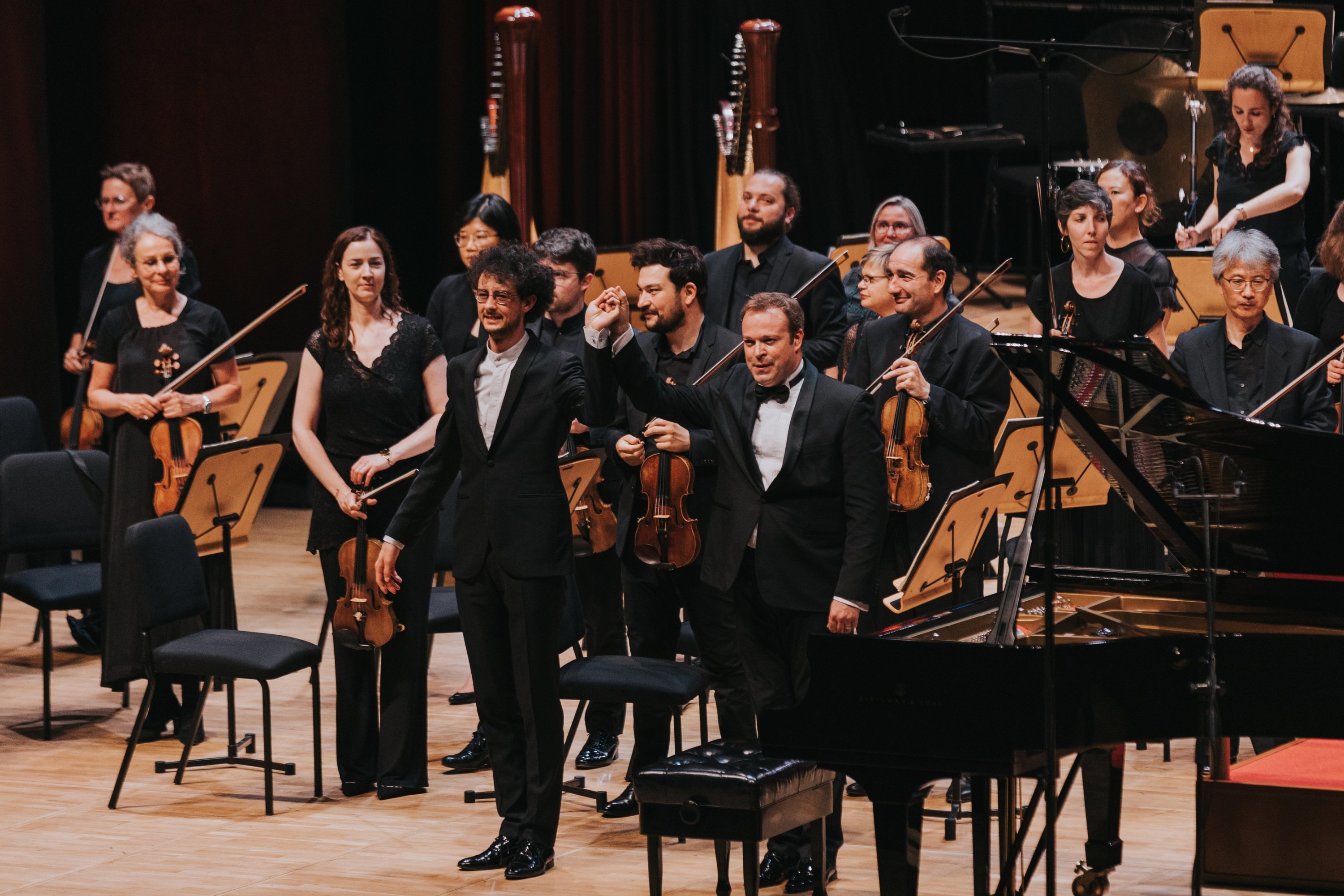 Metz - konduktor Grand Est National Orchestra David Reiland (kiri) dan pianis Turki Can Çakmur memberi hormat kepada penonton setelah konser berakhir, Istanbul, Türkiye, 6 Juli 2023. (Foto milik IKSV)