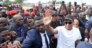 Paris Saint-Germain and France national football team star striker Kylian Mbappe (C-R) greets crowds gathered outside at the Yaounde Airport as he arrives for a charity visit and a tour of his father&#039;s village, Yaounde, Cameroon, July 6, 2023. (AFP Photo)