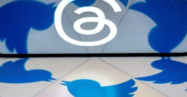This illustration created in Washington, D.C., on July 5, 2023, shows the logo for Threads, an Instagram app, reflected in the Twitter logo.