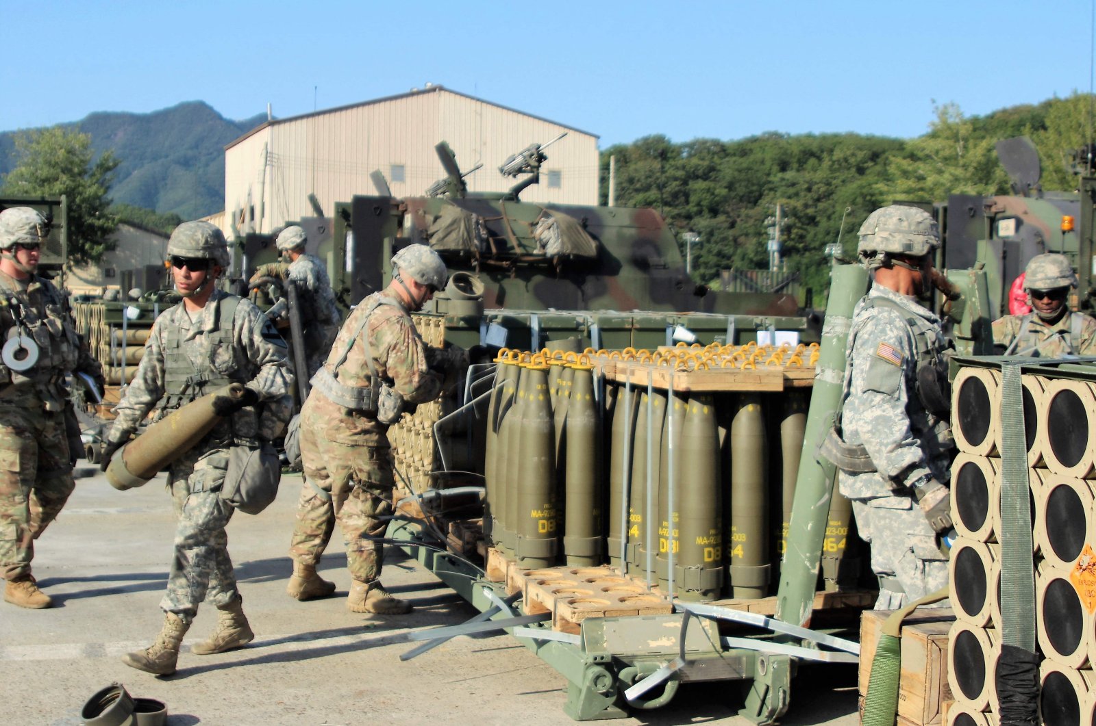 Soldiers draw 155mm Base Burn Dual Purpose Improved Conventional Munition rounds and carry them into their vehicles during a load exercise, undisclosed location, July 7, 2023. (AFP Photo / DVIDS)