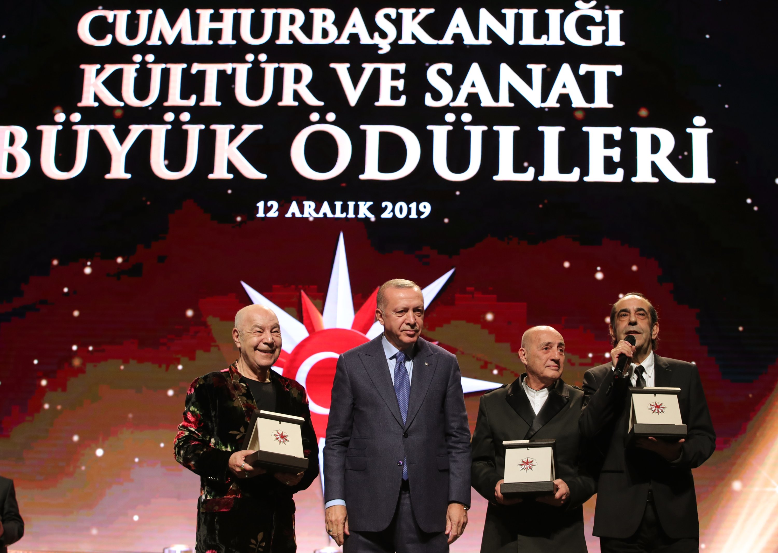 Presiden Recep Tayyip Erdoğan menyerahkan penghargaan kepada grup MFÖ, yang terdiri dari Mazhar Alanson, Fuat Güner, dan Özkan Uğur, yang dianggap layak menerima penghargaan di bidang 'Musik,' Istanbul, Türkiye, 12 Desember 2019. ( Foto AA)