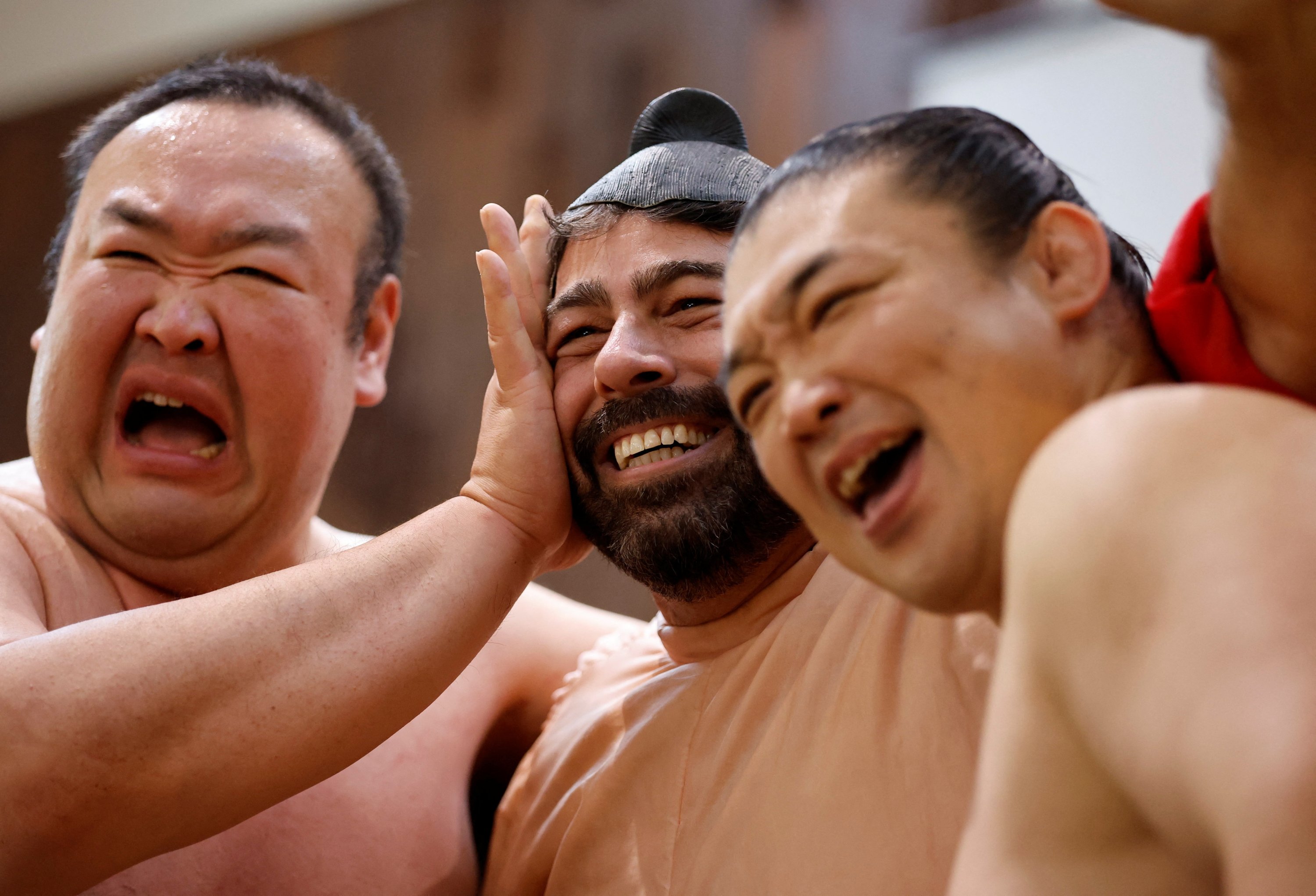 Mantan pegulat sumo Kotoohtori, 40, dan Towanoyama, 45, berfoto dengan turis asal AS yang mengenakan kostum pegulat sumo, Tokyo, Jepang, 30 Juni 2023. (Foto Reuters)
