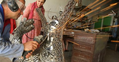 Nurettin Çakmak with his wife Agrin Çakmak makes a Shahmaran sculpture from recycled metal wastes in the Artuklu district of Mardin, Türkiye, July 10, 2023. (AA Photo)